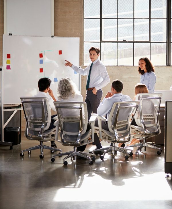 Young male manager using whiteboard in a business meeting